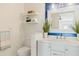 Well-lit bathroom with a white vanity, modern fixtures, floating shelves, and a decorative mirror at 1622 Wisconsin Ln, Sarasota, FL 34239