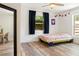 Bright bedroom boasts colorful decor, wood look floors, and two windows with natural light at 1622 Wisconsin Ln, Sarasota, FL 34239