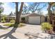 Charming exterior with a brick driveway and attached one car garage with beautiful lush landscaping at 1622 Wisconsin Ln, Sarasota, FL 34239