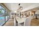 Elegant dining area features a modern light fixture, a large dining table, and sliding glass doors to the pool at 1633 Ridgewood Ln, Sarasota, FL 34231