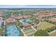 Aerial view of a resort-style community pool, common areas and neighborhood homes with lush tropical landscaping at 16810 Scuba Crest St, Wimauma, FL 33598
