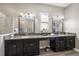 A bathroom with a double vanity, granite countertops, and two large mirrors at 16810 Scuba Crest St, Wimauma, FL 33598