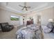 Comfortable bedroom featuring luxury vinyl floors, a ceiling fan, and an en-suite bathroom at 16810 Scuba Crest St, Wimauma, FL 33598