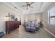 Neutral bedroom showing hardwood flooring, tray ceiling, furnishings, and an en-suite bathroom at 16810 Scuba Crest St, Wimauma, FL 33598
