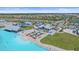 Aerial view of a community pool with sandy beach, lounge chairs and nearby residences at 16810 Scuba Crest St, Wimauma, FL 33598