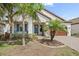 Charming home with a well-manicured lawn, a brick driveway, and tropical landscaping around the entrance at 16810 Scuba Crest St, Wimauma, FL 33598