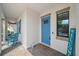 Charming front porch view with blue door, chairs, shutters, and welcome sign at 16810 Scuba Crest St, Wimauma, FL 33598