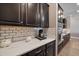 Kitchen featuring white quartz countertops, dark cabinets, subway tile backsplash, and stainless steel appliances at 16810 Scuba Crest St, Wimauma, FL 33598