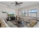 Comfortable living room with wood floors, neutral paint, and two windows providing natural light at 16810 Scuba Crest St, Wimauma, FL 33598