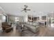 Open concept living room with kitchen and dining areas, wood flooring, and modern light fixtures at 16810 Scuba Crest St, Wimauma, FL 33598