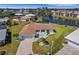 Aerial view of a waterfront home with a lush green lawn, screened in pool, and paved driveway at 1714 Coral Sands Ct, Venice, FL 34293