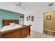 Bright bedroom with a ceiling fan, white bedding, and a green accent wall at 1714 Coral Sands Ct, Venice, FL 34293