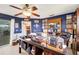 Comfortable home office with wood-look ceiling fan, blue walls, and an oversized, organized desk at 1714 Coral Sands Ct, Venice, FL 34293
