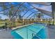 Relaxing screened-in pool with an outdoor seating area and tranquil water views at 1714 Coral Sands Ct, Venice, FL 34293