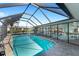 Inviting screened-in pool, enhanced by ample natural light and a peaceful backyard view at 1714 Coral Sands Ct, Venice, FL 34293