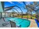 Screened in pool and lanai area with chairs and an open view of the backyard at 1714 Coral Sands Ct, Venice, FL 34293