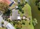 Aerial view of a home with a patio, walkway to the lake, manicured lawn, and mature trees at 1940 35Th N St, St Petersburg, FL 33713