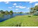Scenic lake view with lush green grass and blue skies with fluffy clouds above the horizon at 1940 35Th N St, St Petersburg, FL 33713