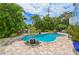 Inviting backyard pool area surrounded by tropical landscaping and brick pavers for outdoor enjoyment at 202 75Th St # A, Holmes Beach, FL 34217