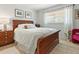 Comfortable bedroom featuring a wood sleigh bed, neutral walls, and lots of natural light from the window at 2526 Clubhouse Dr # 203, Sarasota, FL 34232
