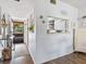 Hallway leading to front door, with view into kitchen with white cabinets at 2526 Clubhouse Dr # 203, Sarasota, FL 34232