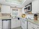 Well-lit kitchen with stainless steel dishwasher and white appliances at 2526 Clubhouse Dr # 203, Sarasota, FL 34232