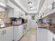 Galley kitchen features white cabinets, stainless steel appliances and tile flooring at 2526 Clubhouse Dr # 203, Sarasota, FL 34232