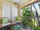 Inviting screened patio featuring comfortable seating and views of lush tropical landscape at 2526 Clubhouse Dr # 203, Sarasota, FL 34232