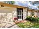 Exterior angle of a tan home featuring a one-car garage, red-bricked front porch, and green lawn at 4223 Oakhurst E Cir # 3025, Sarasota, FL 34233
