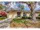Charming single-story home features a lush lawn, a covered porch, and a one-car garage at 4223 Oakhurst E Cir # 3025, Sarasota, FL 34233