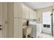 Bright laundry room with washer, dryer, sink, and storage cabinets at 4223 Oakhurst E Cir # 3025, Sarasota, FL 34233
