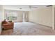 Spacious living room with neutral carpet, ceiling fan, and large front window at 4223 Oakhurst E Cir # 3025, Sarasota, FL 34233