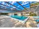 Community pool featuring crystal clear water with a screened in overhead structure and surrounding lounge seating at 4223 Oakhurst E Cir # 3025, Sarasota, FL 34233