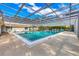 Community pool featuring crystal clear water with a screened in overhead structure and surrounding lounge seating at 4223 Oakhurst E Cir # 3025, Sarasota, FL 34233