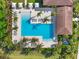 Aerial view of community pool and amenities featuring lounge chairs, umbrellas, and a covered structure at 4790 Pastel Ct, Sarasota, FL 34240