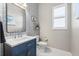 Bathroom with designer wallpaper, blue vanity with marble countertop, and modern finishes at 4790 Pastel Ct, Sarasota, FL 34240