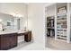 Bathroom with dark wood cabinets, light counters, and a closet full of shelving at 4790 Pastel Ct, Sarasota, FL 34240