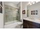 Bathroom featuring tub-shower combo, tile surround, granite counters and dark wood cabinets at 4790 Pastel Ct, Sarasota, FL 34240