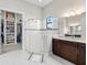 A luxurious bathroom with a glass shower and marble floors, as well as a view of a large walk-in closet at 4790 Pastel Ct, Sarasota, FL 34240