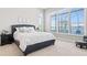 This bedroom features a tufted headboard, neutral tones, and large windows for plenty of natural light at 4790 Pastel Ct, Sarasota, FL 34240