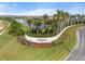 Elegant entrance to the Artistry community with lush landscaping, a beautiful lake view, and a welcoming atmosphere at 4790 Pastel Ct, Sarasota, FL 34240