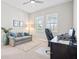 This home office features a plush couch, a large desk, and two bright windows at 4790 Pastel Ct, Sarasota, FL 34240