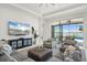Spacious living room featuring modern decor, a large TV, and sliding glass doors leading to the outdoor pool area at 4790 Pastel Ct, Sarasota, FL 34240