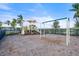 Community playground with a slide, swing set, and other play structures surrounded by palm trees and a lush green lawn at 4790 Pastel Ct, Sarasota, FL 34240
