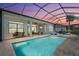 Sparkling screened pool with beautiful sunset views, surrounded by a brick patio and outdoor seating area at 4790 Pastel Ct, Sarasota, FL 34240
