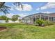 Landscaped backyard featuring a screened-in pool, lush lawn, and well-maintained flowerbeds providing a serene outdoor space at 4920 Breakwater Dr, Bradenton, FL 34203