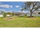 Expansive backyard with lush green grass, mature tree, vegetable garden, and screened-in pool at 4920 Breakwater Dr, Bradenton, FL 34203