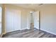 Bedroom with neutral walls, wood-look floors, double closet doors, and open doorway at 4920 Breakwater Dr, Bradenton, FL 34203