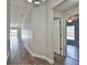 Long hallway with wood-look flooring leading to various rooms, with natural light from the windows at 4920 Breakwater Dr, Bradenton, FL 34203