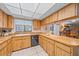 Bright kitchen featuring wood cabinetry, stainless steel appliances, tile floors, and a view of the dining area at 5322 Ruby Ln, Sarasota, FL 34231